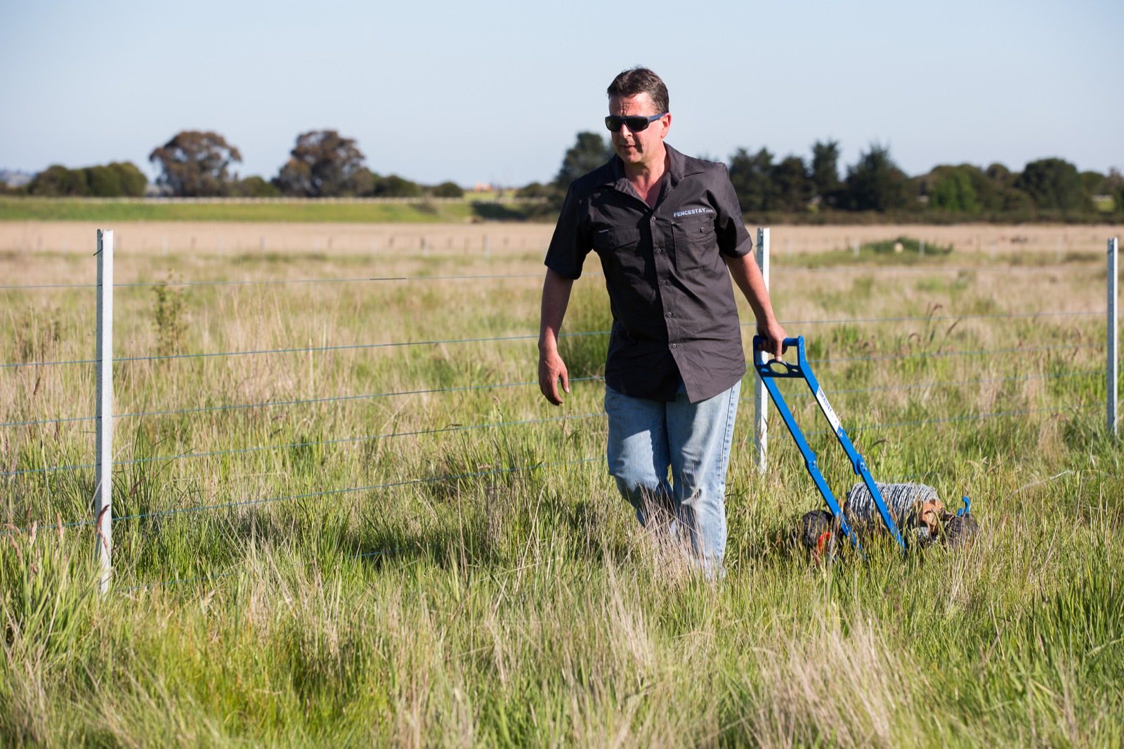 Running out fence wire by hand along the fence line
