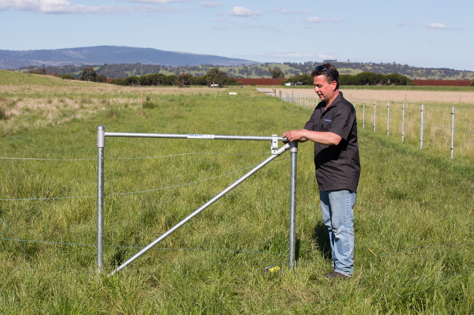 Property owner standing beside an installed FenceStay end assembly