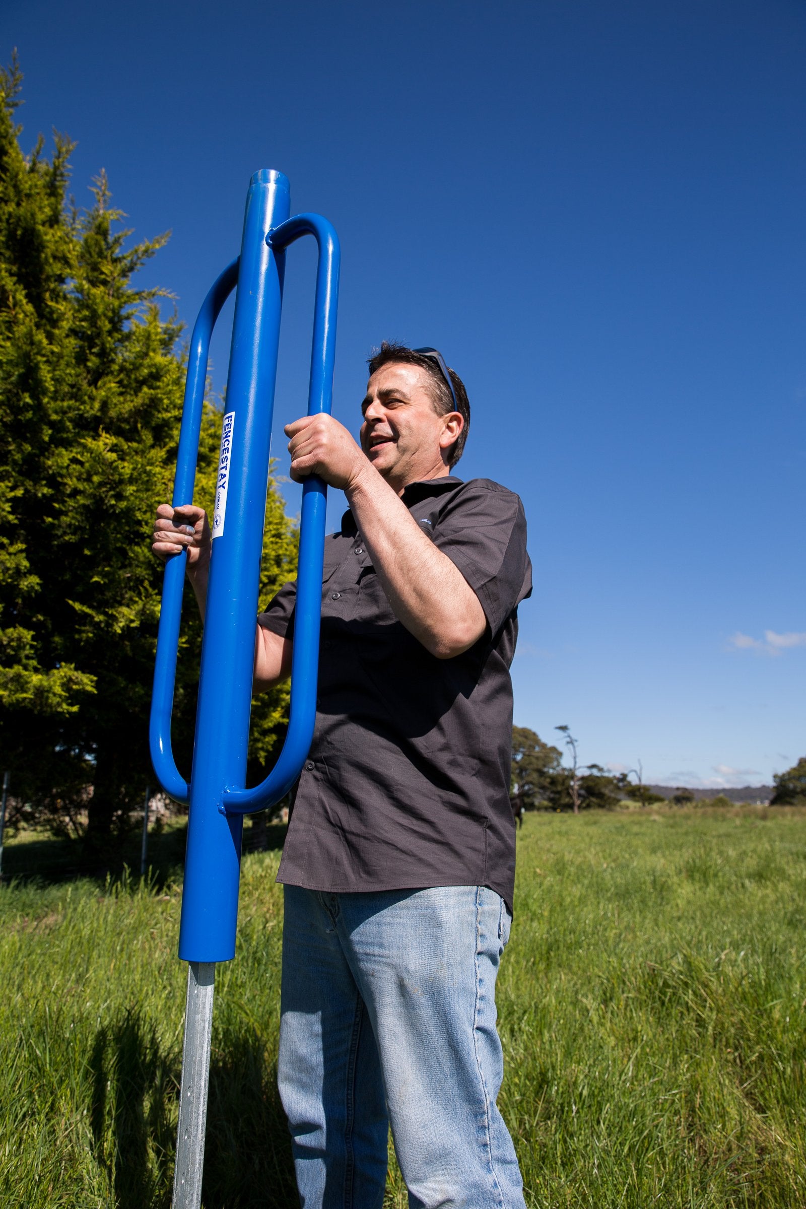 Man driving a star picket with blue post driver
